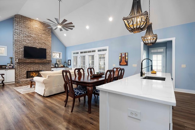 316 Birch Ln, Pine Mountain, GA 31822 - dining space with high vaulted ceiling, dark wood-style flooring, a chandelier, ceiling fan, and a brick fireplace