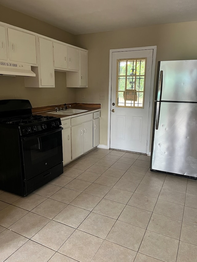 kitchen with white cabinetry, sink, stainless steel refrigerator, and black gas stove