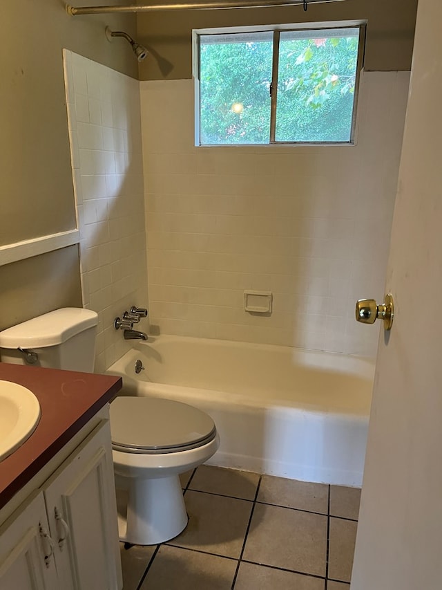 full bathroom featuring vanity, tiled shower / bath combo, tile patterned floors, and toilet