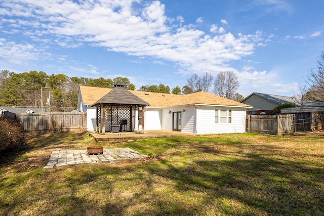 rear view of property with a fire pit, a lawn, a fenced backyard, a gazebo, and a patio area