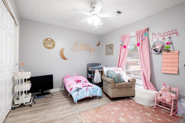 bedroom with a textured ceiling, ceiling fan, wood finished floors, baseboards, and a closet