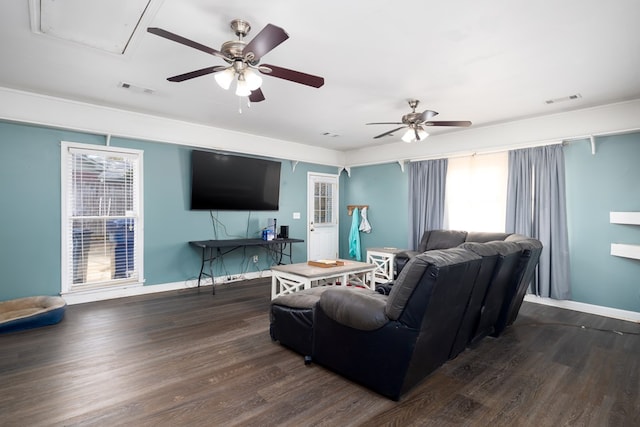 living area featuring a wealth of natural light, visible vents, and wood finished floors