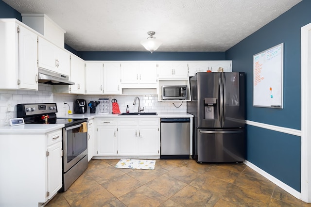 kitchen featuring appliances with stainless steel finishes, a sink, white cabinetry, and under cabinet range hood