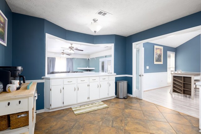 bathroom featuring baseboards, visible vents, a ceiling fan, a textured ceiling, and vanity