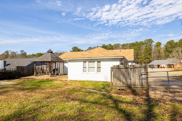 back of house featuring a gazebo, a patio, fence private yard, and a lawn