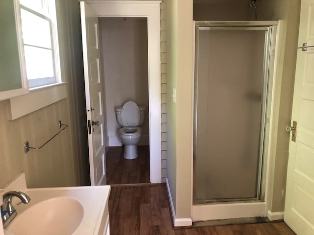 bathroom featuring hardwood / wood-style floors, vanity, toilet, and walk in shower