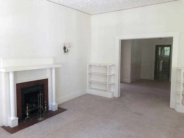 unfurnished living room featuring a fireplace, light colored carpet, and a textured ceiling