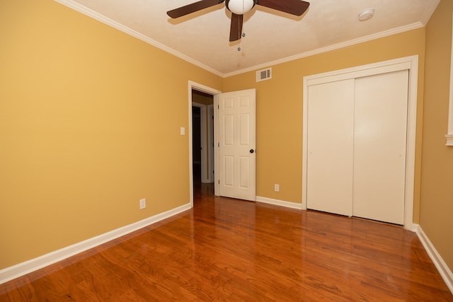 unfurnished bedroom with ceiling fan, crown molding, and wood-type flooring