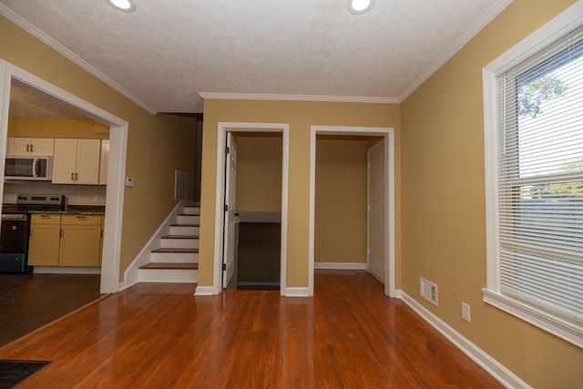 unfurnished living room featuring crown molding, a textured ceiling, and hardwood / wood-style flooring