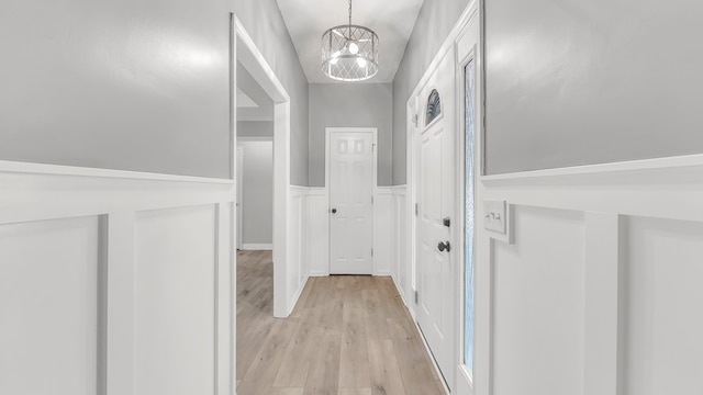 hall featuring light hardwood / wood-style floors and a chandelier