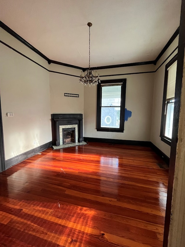 unfurnished living room with plenty of natural light, hardwood / wood-style floors, and ornamental molding