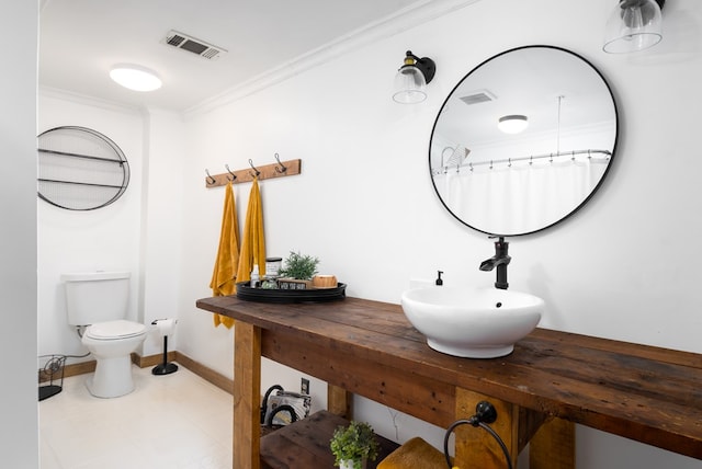 bathroom featuring curtained shower, toilet, double sink, and ornamental molding