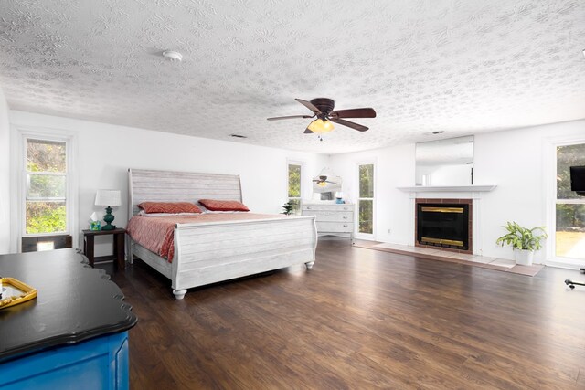 bedroom with ceiling fan, dark hardwood / wood-style flooring, and a textured ceiling