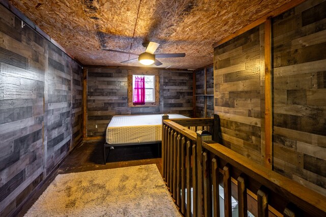 bedroom with wooden walls and ceiling fan