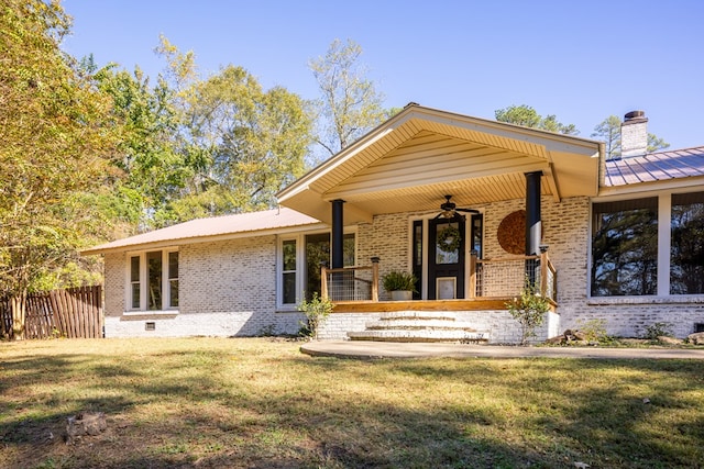 view of front of property featuring ceiling fan, covered porch, and a front lawn