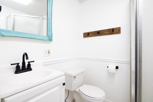 bathroom with vanity, toilet, and walk in shower