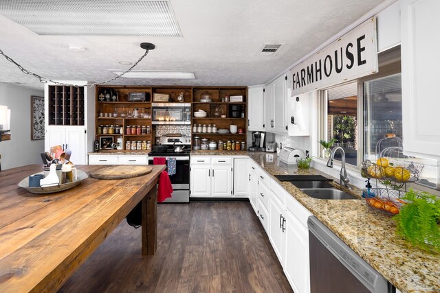 kitchen with white cabinets, sink, dark hardwood / wood-style floors, a textured ceiling, and stainless steel appliances