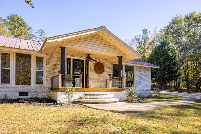 view of front of house featuring ceiling fan, a porch, and a front lawn