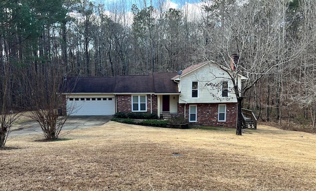 tri-level home featuring a garage and a front lawn