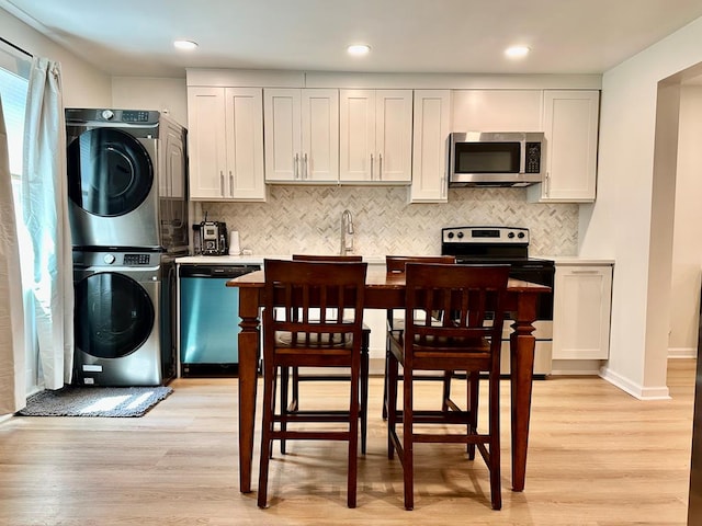 6231 Lynridge Ave, Columbus, GA 31909 - kitchen featuring appliances with stainless steel finishes, stacked washer / drying machine, light countertops, light wood-type flooring, and recessed lighting