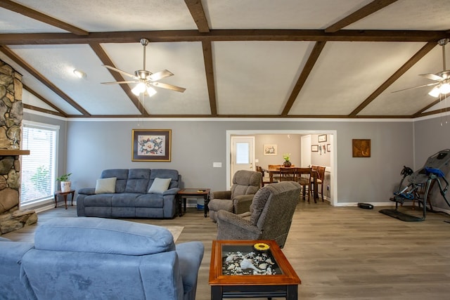 living room with baseboards, lofted ceiling with beams, light wood-style flooring, a fireplace, and ceiling fan