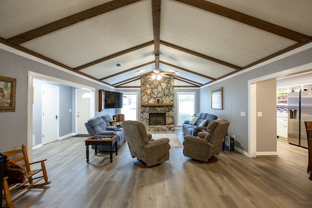 living room featuring a fireplace, vaulted ceiling with beams, ceiling fan, and wood finished floors