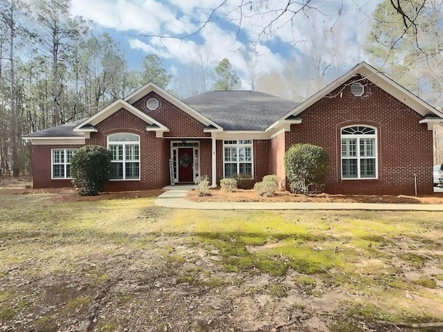 single story home featuring brick siding and a front yard