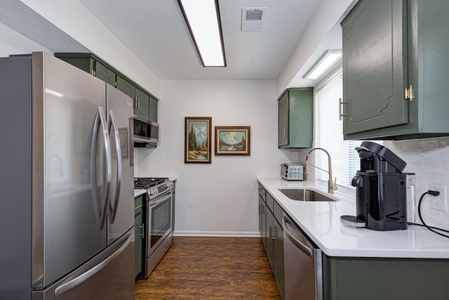 1305 Forest Ave Unit 00011, Columbus, GA 31906 - kitchen with appliances with stainless steel finishes, green cabinets, a sink, dark wood-style floors, and light countertops