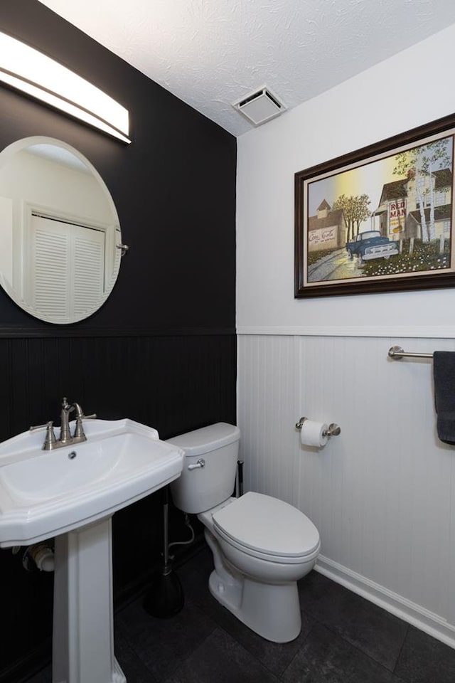 1305 Forest Ave Unit 00011, Columbus, GA 31906 - bathroom with toilet, wainscoting, baseboards, tile patterned floors, and a textured ceiling