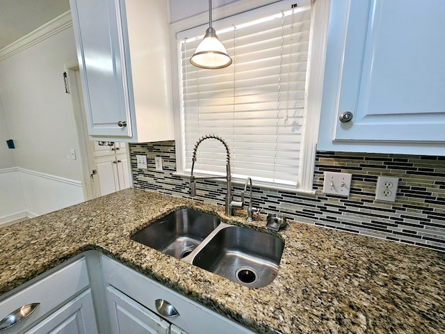 kitchen with decorative backsplash, white cabinets, pendant lighting, and ornamental molding