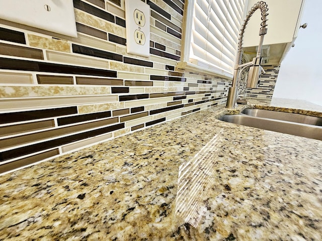 interior details featuring light stone countertops and sink