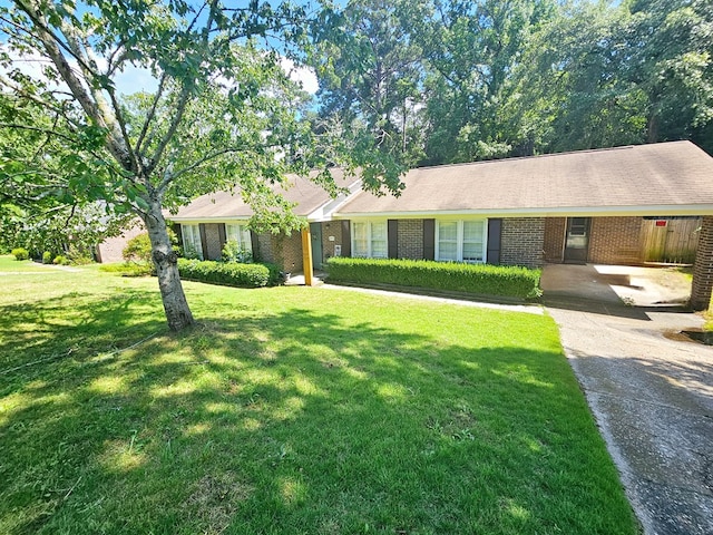 ranch-style home featuring a front lawn and a carport