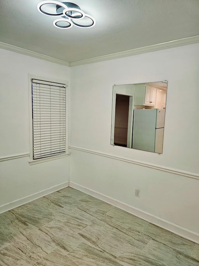 unfurnished room featuring a textured ceiling and crown molding