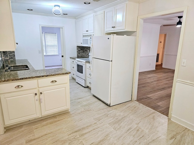 kitchen with white appliances, dark stone counters, white cabinets, sink, and tasteful backsplash