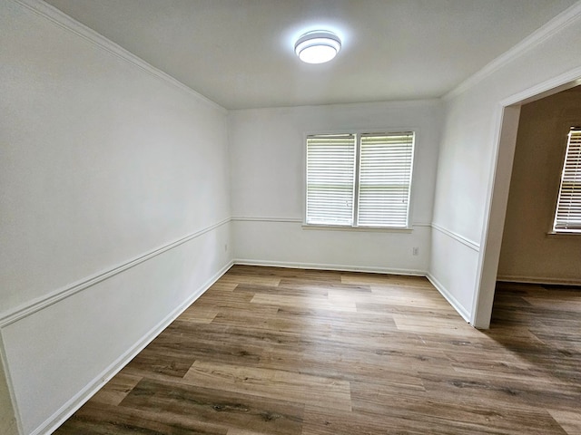 unfurnished room featuring hardwood / wood-style floors and crown molding