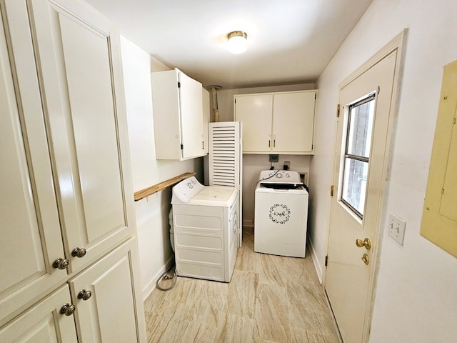 laundry room featuring electric panel, cabinets, and independent washer and dryer