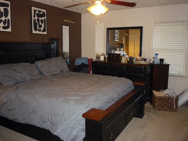 bedroom featuring ceiling fan, a textured ceiling, and carpet flooring