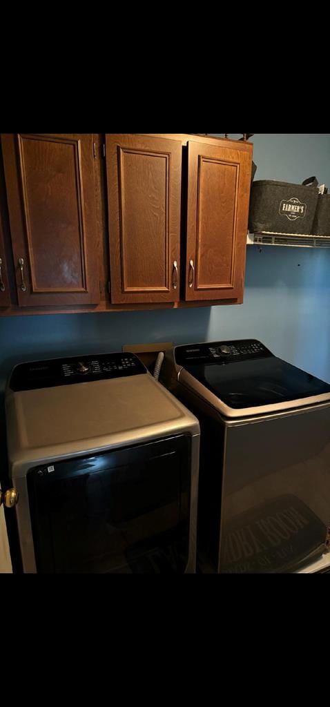 laundry room with washing machine and dryer and cabinet space