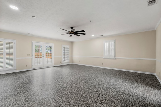 empty room featuring plenty of natural light, french doors, visible vents, and a textured ceiling