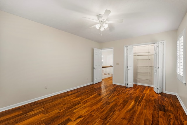 unfurnished bedroom featuring a closet, baseboards, wood finished floors, and a ceiling fan