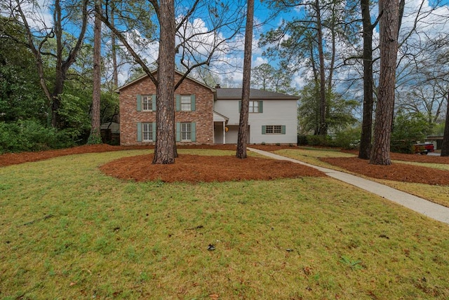 traditional-style house with brick siding and a front yard