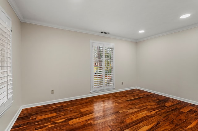 unfurnished room featuring baseboards, wood finished floors, visible vents, and ornamental molding