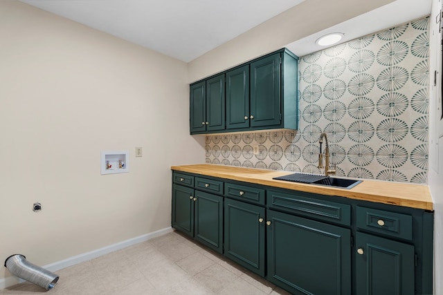 washroom with baseboards, washer hookup, light tile patterned floors, cabinet space, and a sink