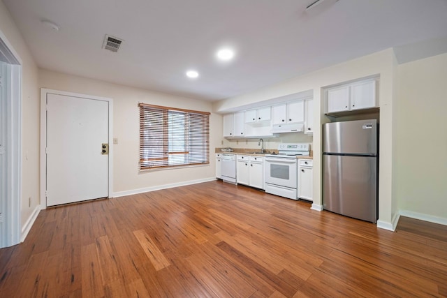 2231 Holly Ln, Pine Mountain, GA 31822 - kitchen with white appliances, under cabinet range hood, white cabinetry, wood finished floors, and recessed lighting