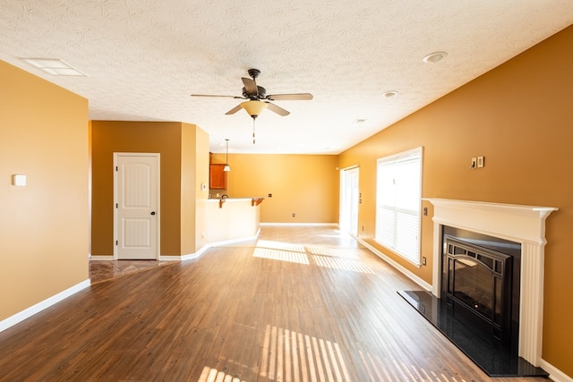 1 Cambridge Ct, Phenix City, AL 36870 - unfurnished living room with wood finished floors, ceiling fan, a glass covered fireplace, baseboards, and a textured ceiling