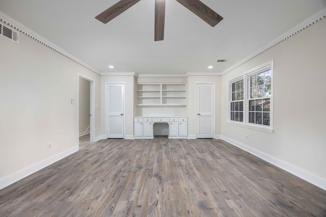 unfurnished living room featuring ornamental molding, wood-type flooring, built in desk, and ceiling fan