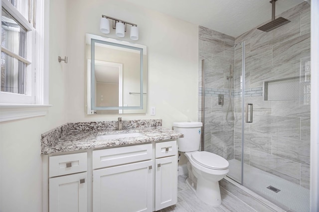 bathroom with vanity, toilet, and walk in shower