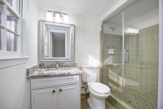 bathroom featuring vanity, an enclosed shower, and toilet