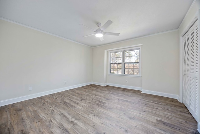 unfurnished bedroom with crown molding, light hardwood / wood-style flooring, a closet, and ceiling fan