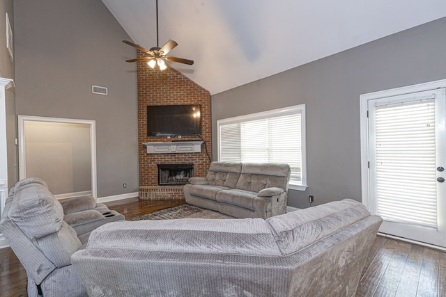 living room with dark hardwood / wood-style flooring, high vaulted ceiling, ceiling fan, and a fireplace